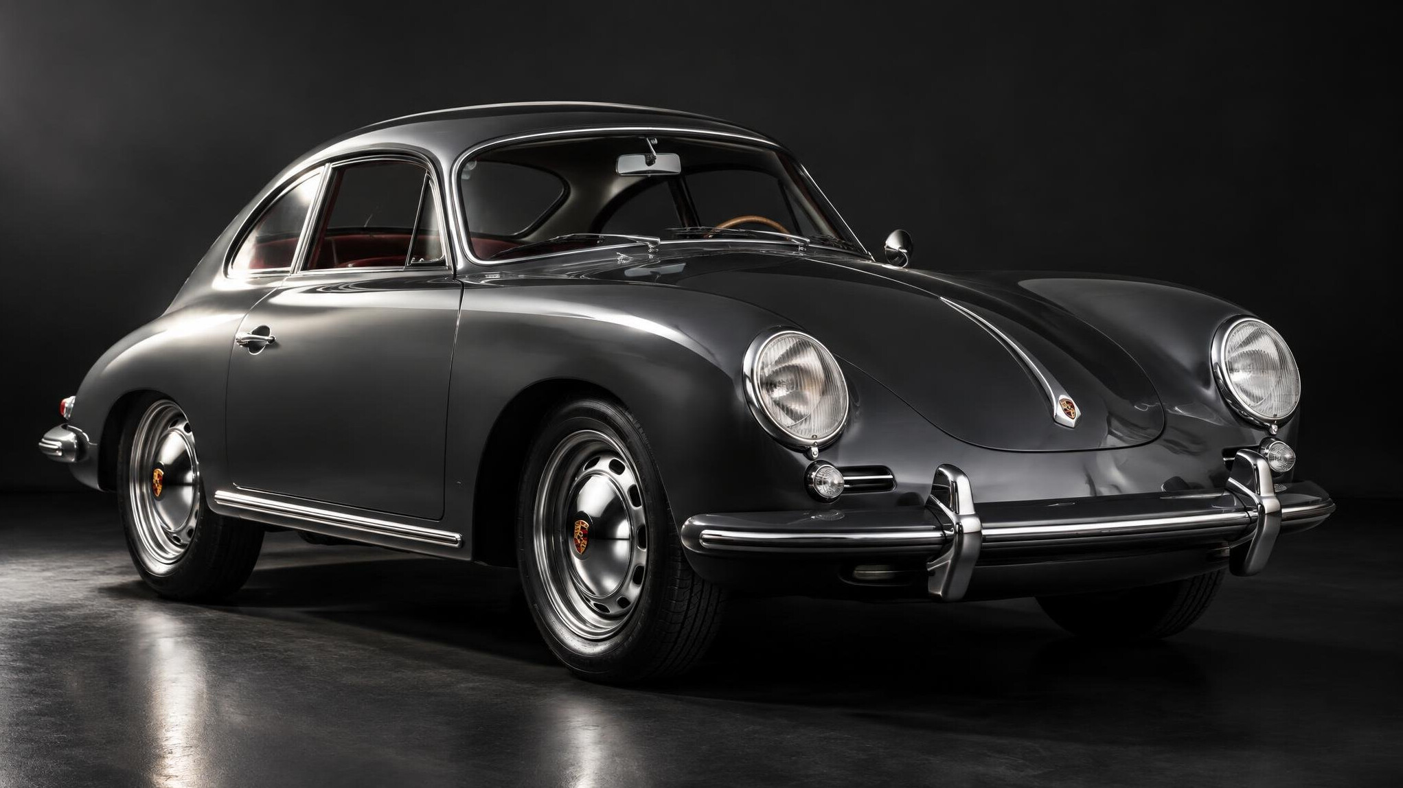 Restored 1950s European sports car photographed in a studio setting